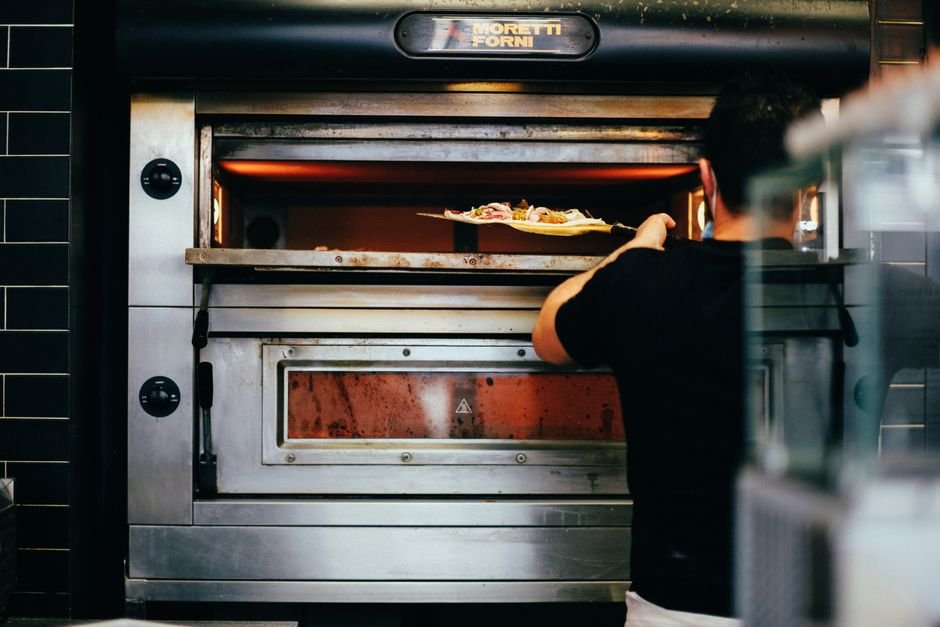 Un four à pizza à gaz de différentes tailles avec des pizzas fraîchement cuites.